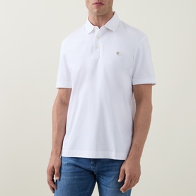 Model wearing Boss Black Casual C-Parris Logo Polo Shirt in white, with polo collar, two-button placket and chest logo embroidery, styled with blue