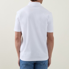 Model wearing Boss Black Casual C-Parris Logo Polo Shirt in white. Back view, short sleeves, straight hem with side splits. Styled with blue jeans.