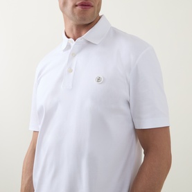 Model wearing Boss Black Casual C-Parris Logo Polo Shirt in white, showing tonal chest logo embroidery and two-button placket detail.