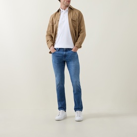 Model wearing Boss Black Casual C-Parris White Polo Shirt, styled with tan overshirt, mid-blue slim jeans and white trainers