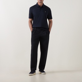 Model wearing Boss Black Casual C-Parris Double B Logo Polo Shirt in dark blue, styled with black trousers and white trainers.