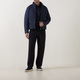 Model wearing Boss Black Casual C-Parris Double B Logo Polo Shirt in dark blue, styled with a navy quilted jacket and black trousers.