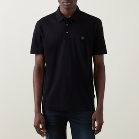 Model wearing Boss Black Casual black cotton polo shirt with short sleeves and logo badge, styled with dark jeans