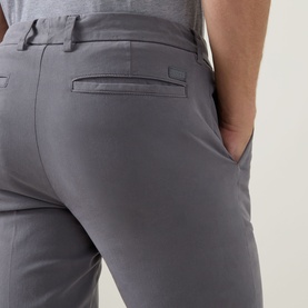 Model wearing Boss Black Casual dark grey slim-fit trousers, rear view showing back pocket and tailored waistband detail.
