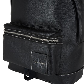 Calvin Klein black backpack, silver-tone zip detail, pebbled faux leather texture, logo patch on front pocket