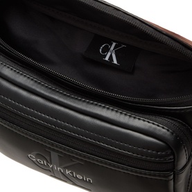 Calvin Klein Bold Logo Belt Bag in black, open interior view showing CK monogram lining and silver-tone zip hardware detail.