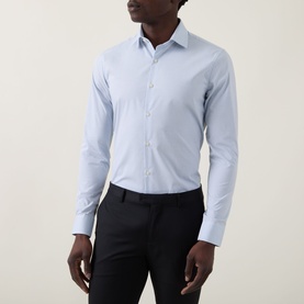 Model wearing Calvin Klein The Poplin Dotted Shirt in Blue Dot, slim fit with single cuffs and long sleeves, styled with dark trousers.