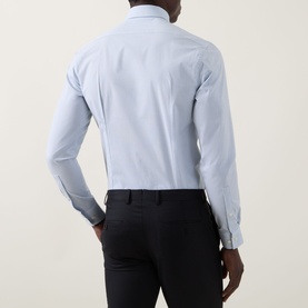 Model wearing Calvin Klein The Poplin Dotted Shirt in Blue Dot, single cuff slim fit, rear view, styled with black trousers.