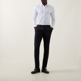 Model wearing Calvin Klein The Poplin Slim Fit Shirt in white with pointed collar, styled with black slim trousers and black dress shoes.