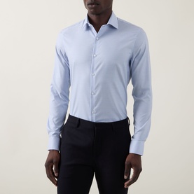 Model wearing Calvin Klein Check Slim Fit Non-Iron Shirt in Blue Check, slim fit with pointed collar and single cuffs, styled with navy trousers.