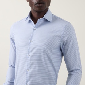 Model wearing Calvin Klein Check Slim Fit Non-Iron Shirt in blue check, featuring pointed collar and button fastening, slim fit silhouette.