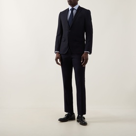 Model wearing Calvin Klein Blue Check Slim Fit Non-Iron Shirt styled with navy suit, tie, and black leather dress shoes.