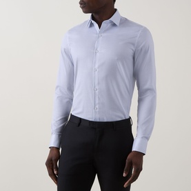 Model wearing Calvin Klein Geometric Single-Cuff Shirt in Blue Geo, slim fit with classic collar and long sleeves, styled with black trousers.