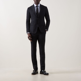 Model wearing Calvin Klein Blue Geo Geometric Single-Cuff Shirt, styled with a dark navy suit, tie, and black leather shoes.