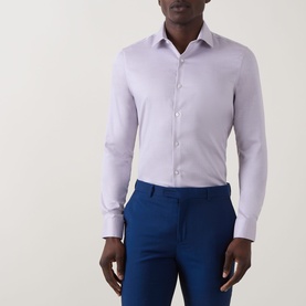 Model wearing Calvin Klein Stretch Single-Cuff Shirt in Burgundy, classic collar, long sleeves, styled with blue trousers.