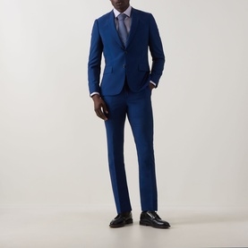 Model wearing Calvin Klein Burgundy Stretch Single-Cuff Shirt, styled with a blue suit, blue tie, and black leather shoes.
