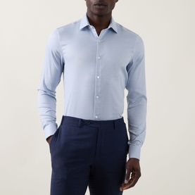 Model wearing Calvin Klein Check Slim Fit Non-Iron Shirt in blue, styled with navy slim-fit trousers.