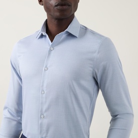 Model wearing Calvin Klein Check Slim Fit Non-Iron Shirt in blue, slim fit with pointed collar and button fastenings, paired with navy trousers.