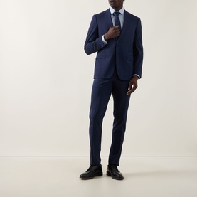 Model wearing Calvin Klein Blue Check Slim Fit Non-Iron Shirt, styled with a navy suit, blue tie, and black leather shoes.