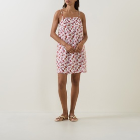 Model wearing Seafolly ecru floral mini dress with thin straps, styled with tan strappy flat sandals