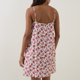 Model wearing Seafolly ecru mini dress with red floral print, spaghetti straps and relaxed silhouette, shown from the back.