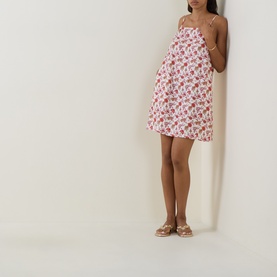 Model wearing Seafolly ecru floral mini dress with spaghetti straps, styled with gold flat sandals
