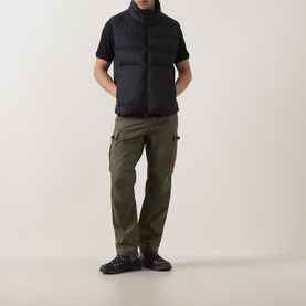 Model wearing Boss Green Label black polyester gilet with funnel neck, styled with olive cargo trousers and black trainers