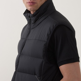 Model wearing Boss Green Label black quilted polyester gilet with funnel neck, styled with a black short-sleeve top.