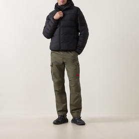 Model wearing Boss Green Label black gilet with olive cargo trousers and dark chunky trainers