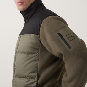Model wearing Boss Green Label Open Green jacket with black quilted panelling, zip chest pocket, and branded sleeve patch detail