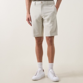 Model wearing Boss Green Label Commuter 10.5" Golf Shorts in light beige, slim fit, styled with white trainers and socks.