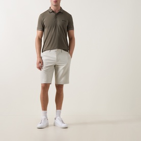 Model wearing Boss Green Label Commuter 10.5" Golf Shorts in light beige, slim fit, styled with a khaki polo shirt and white trainers.
