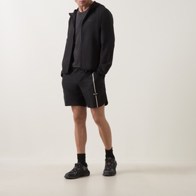 Model wearing Boss Green Label TOC Game 8" Golf Shorts in black with side slits, paired with matching black zip jacket and trainers.