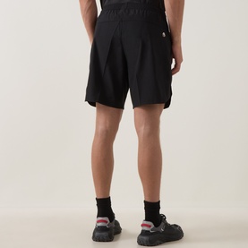 Model wearing Boss Green Label TOC Game 8" Golf Shorts in black, shown from behind, styled with black socks and trainers.