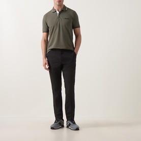 Model wearing Boss Green Label Goc Swing Water-Repellent Trousers in black, styled with an olive polo shirt and grey trainers.