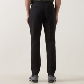 Model wearing Boss Green Label Goc Swing Water-Repellent Trousers in black, styled with grey trainers. Rear view showing clean tailored fit.