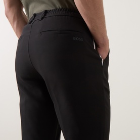 Model wearing Boss Green Label Goc Swing Water-Repellent Trousers in black, showing rear welt pocket and tonal logo print detail.