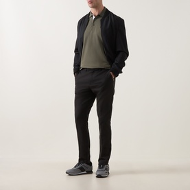 Model wearing Boss Green Label Goc Swing Water-Repellent Trousers in black, styled with olive polo shirt and black bomber jacket.