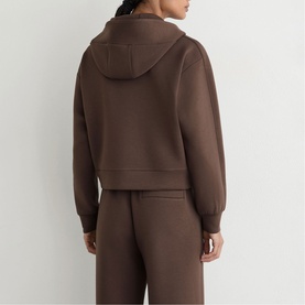Model wearing Reiss mocha brown hoodie, back view, styled with matching wide-leg trousers