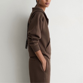 Model wearing Reiss mocha brown zip-neck sweatshirt, styled with matching wide-leg trousers in coordinating set