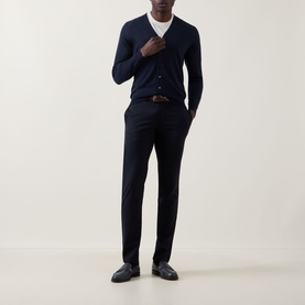 Model wearing John Smedley Bradrick Fine Knit Navy Cardigan with white tee, tailored navy trousers and brown leather belt.