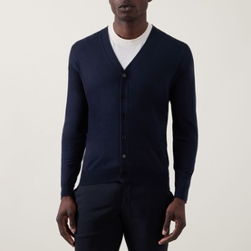 Model wearing John Smedley Bradrick Fine Knit Cardigan in navy, V-neck with button placket, styled over a white T-shirt with navy trousers.