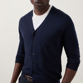 Model wearing John Smedley Bradrick Fine Knit Cardigan in navy, V-neck with button placket, styled over a white T-shirt