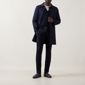 Model wearing John Smedley Bradrick Fine Knit Navy Cardigan with navy coat, white tee, navy trousers and dark leather shoes.