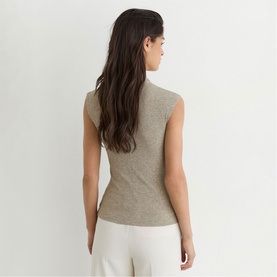 Model wearing Reiss gold sleeveless ribbed top, back view, styled with white wide-leg trousers