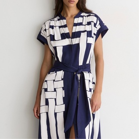 Model wearing navy and white geometric print midi dress with V-neck, cap sleeves, and self-tie waist belt