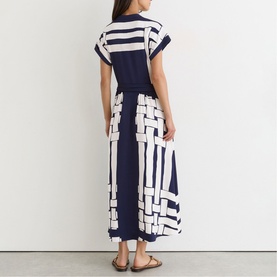 Model wearing navy and white geometric stripe print maxi dress with short sleeves and belted waist, shown from the back
