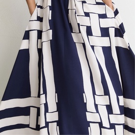 Navy and white geometric print midi skirt with full A-line silhouette and side pockets, close-up detail shot