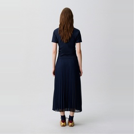 Model wearing Claude Pierlot blue pleated midi skirt and navy short-sleeve top, rear view, styled with gold metallic sandals.