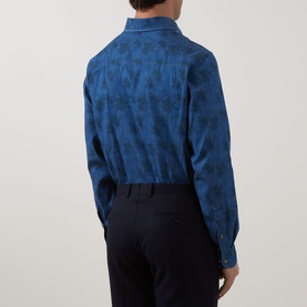 Model wearing Eton Floral Denim Shirt in denim blue, rear view showing floral pattern, cut-away collar and single cuffs, styled with navy trousers.